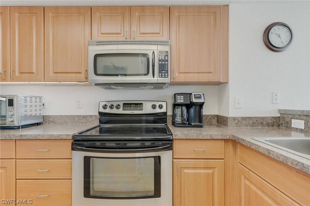 16641 Stringfellow Road, Unit 502 Bokeelia, FL 33922 - Photo 7 of 40 a kitchen with granite countertop white cabinets and a stove top oven