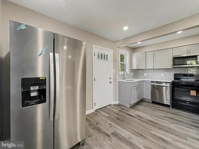 a kitchen with a refrigerator sink and cabinets