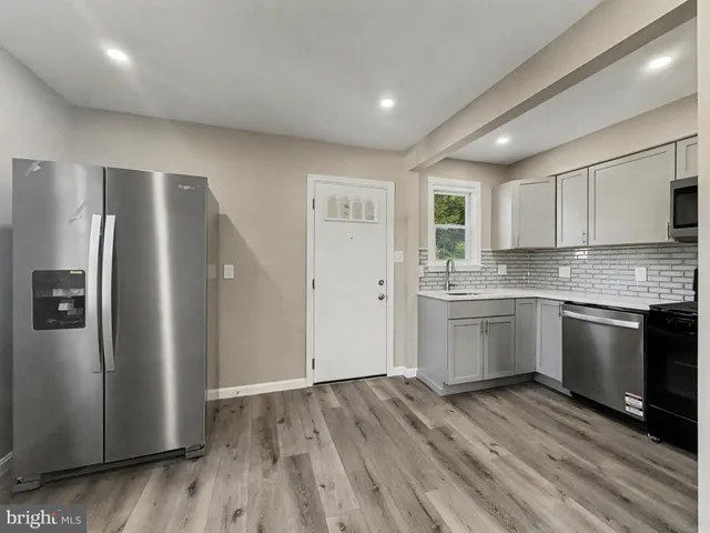 a kitchen with a refrigerator and a stove top oven