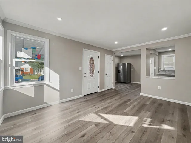 a view of an empty room with closet and wooden floor