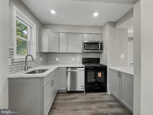 a kitchen with a sink stove and microwave