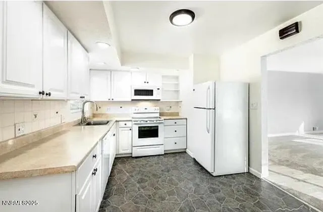 a kitchen with white cabinets and white appliances