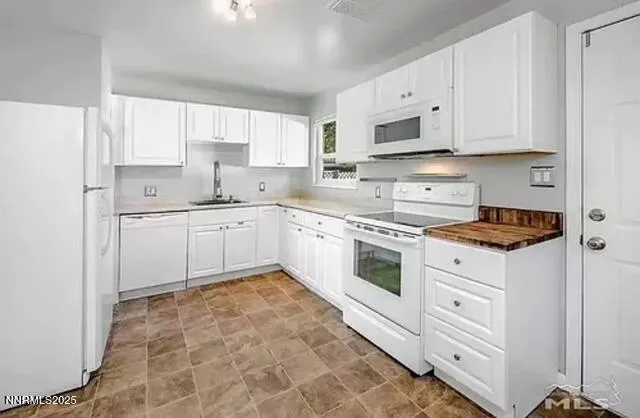 a kitchen with white cabinets stainless steel appliances and sink