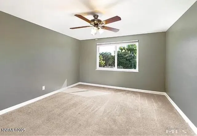 an empty room with a window and a ceiling fan