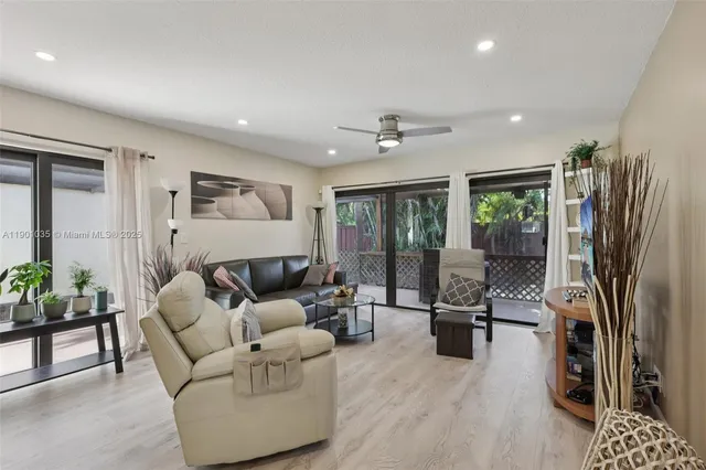a living room with furniture floor to ceiling window and wooden floor