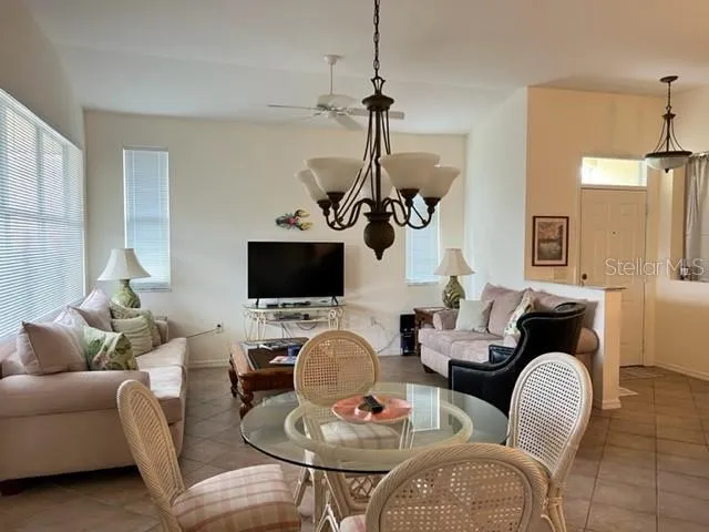 a living room with furniture a flat screen tv and a window