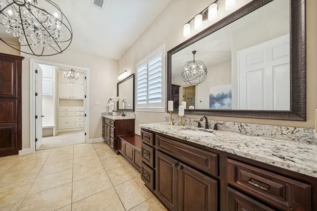 a bathroom with a granite countertop sink and a large mirror