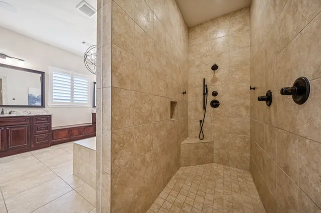 a bathroom with a granite countertop sink a mirror and shower