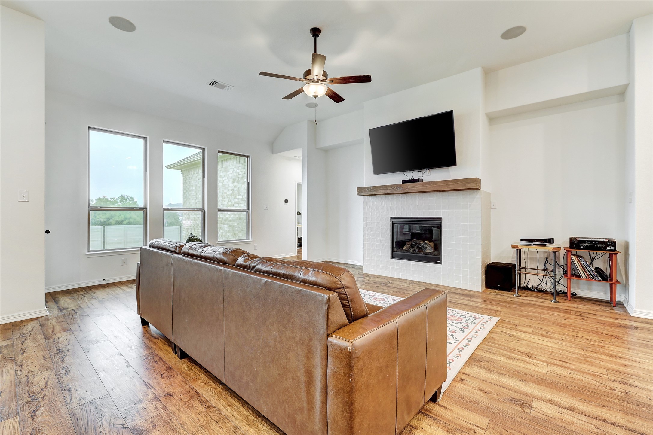 1117 Spring Gulch Lane Georgetown, TX 78628 - Photo 15 of 39 A well-lit living area showcases rich hardwood flooring and a stylish fireplace with a sleek mantel.