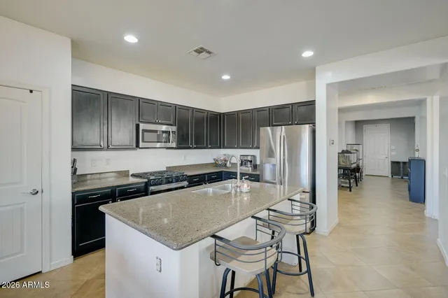 a kitchen with a stove a refrigerator and a dining table
