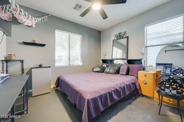 a bed sitting in a bedroom next to a window and a chandelier