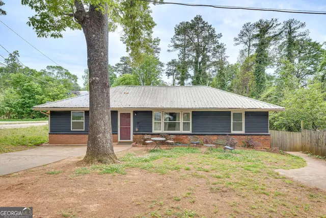 a front view of house with yard and trees around