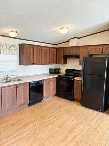 a kitchen with stainless steel appliances kitchen island granite countertop a refrigerator and a sink