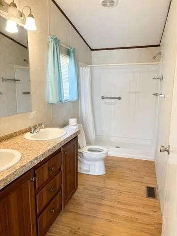 a bathroom with a granite countertop sink toilet and shower