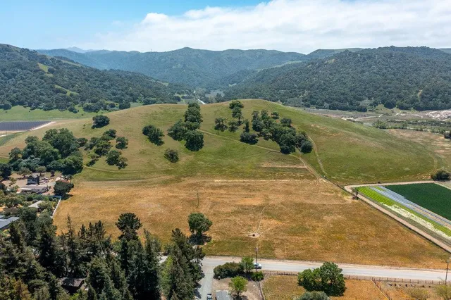 a view of a field with mountains in the background