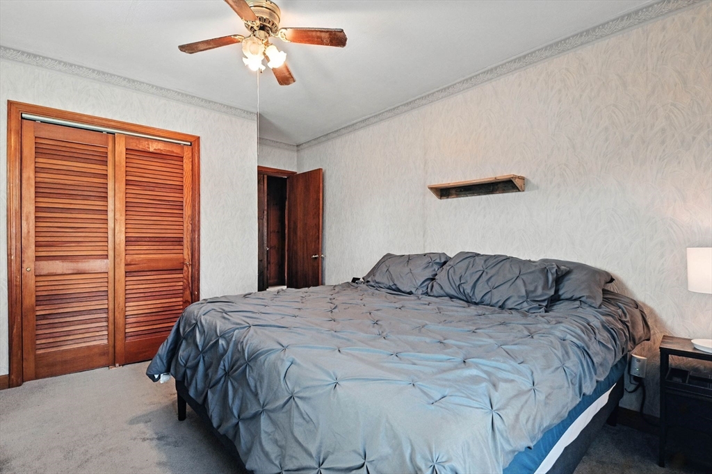 138 Suffield Street Agawam, MA 01001 - Photo 25 of 42 a bedroom with a bed and a chandelier