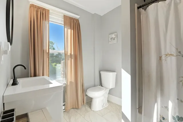 a bathroom with a toilet sink and shower