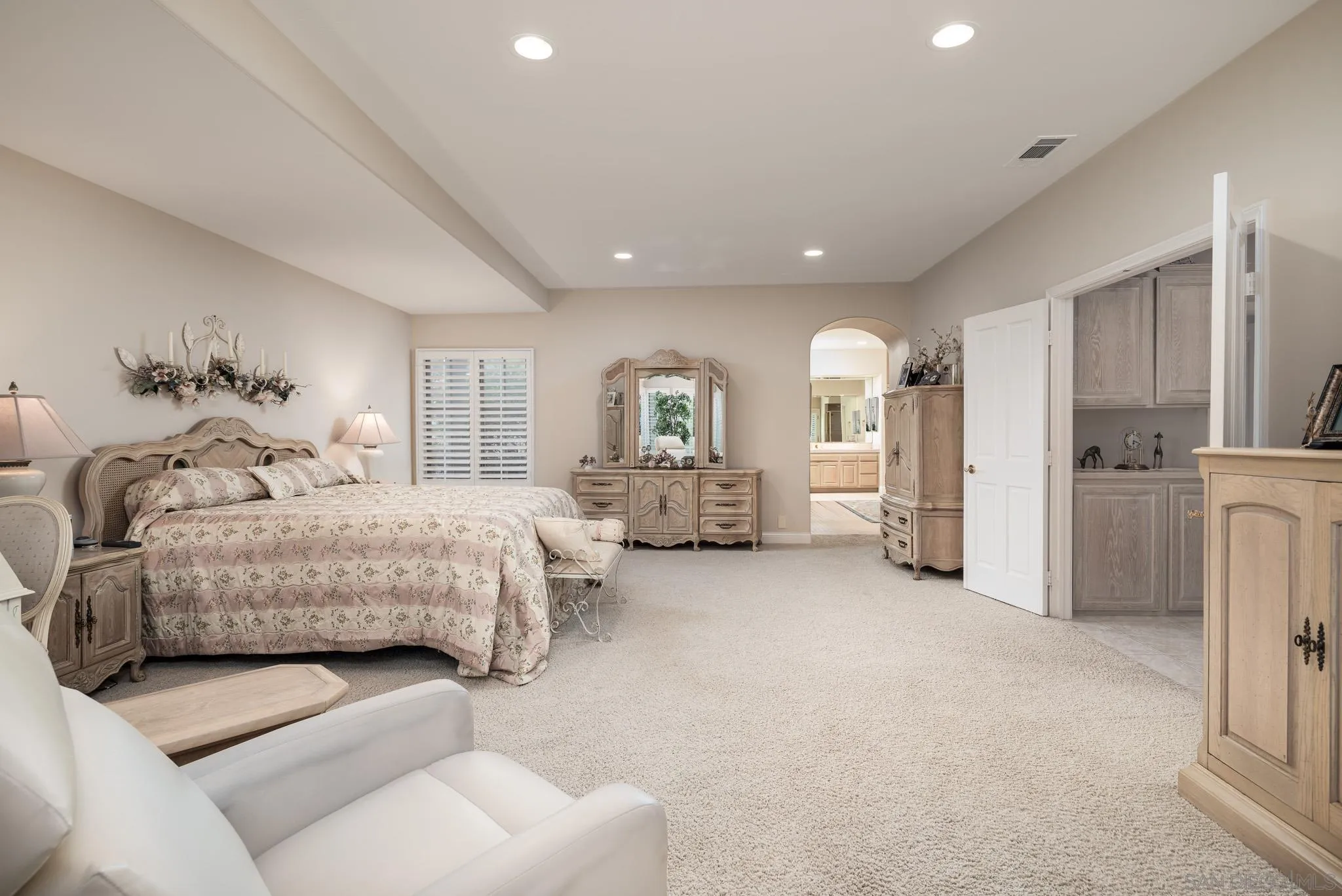 18221 Via Ascenso Rancho Santa Fe, CA 92067 - Photo 20 of 37 a spacious bedroom with a bed a couch and cabinet