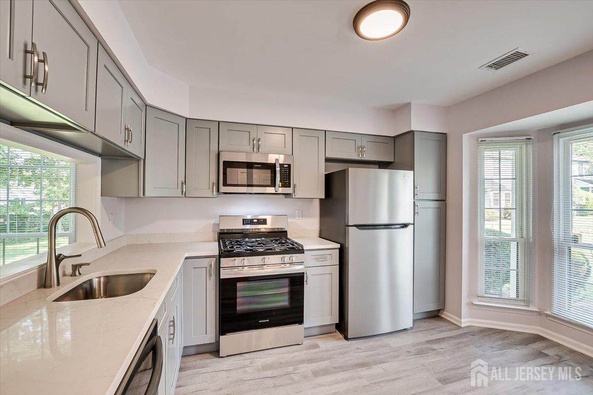 706 Maplecrest Road Edison, NJ 08820 - Photo 11 of 34 a kitchen with granite countertop a sink stove and refrigerator
