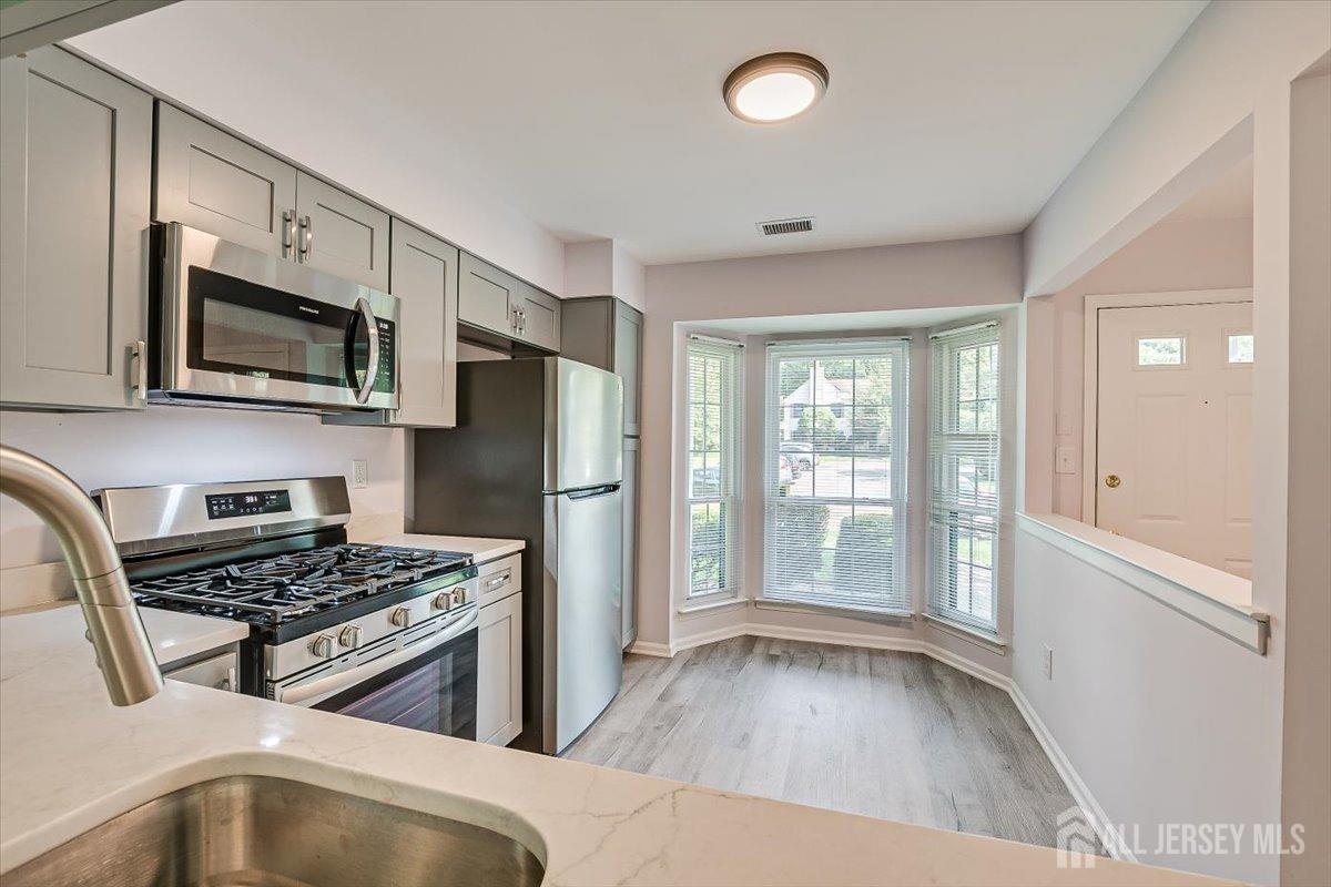 706 Maplecrest Road Edison, NJ 08820 - Photo 15 of 34 a kitchen with a refrigerator stove and wooden cabinets