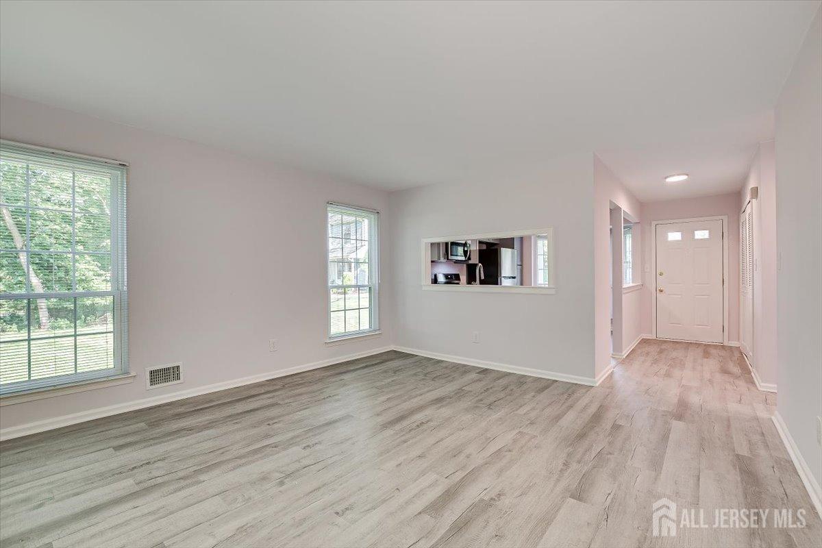 706 Maplecrest Road Edison, NJ 08820 - Photo 18 of 34 an empty room with wooden floor and windows