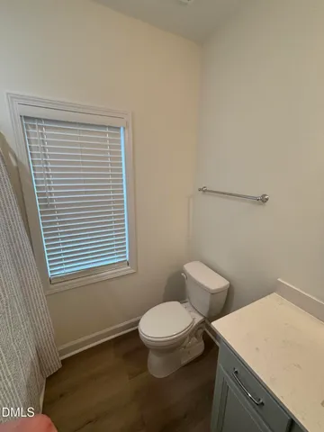 a bathroom with a toilet a sink and a window