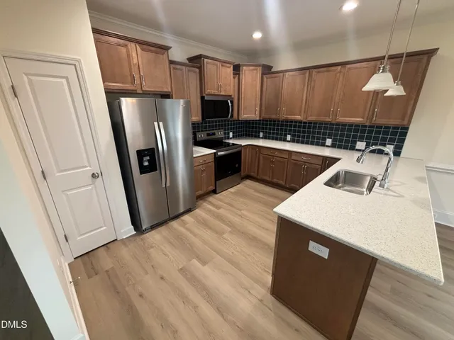 a kitchen with a sink a refrigerator a stove a microwave and cabinets