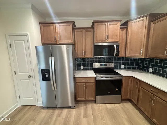 a kitchen with stainless steel appliances a refrigerator sink and cabinets