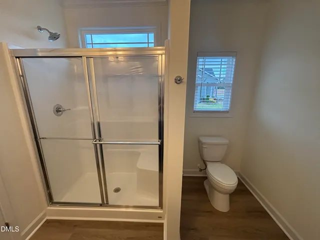 a bathroom with a toilet and a shower