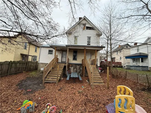 a view of a chair and table in backyard of the house