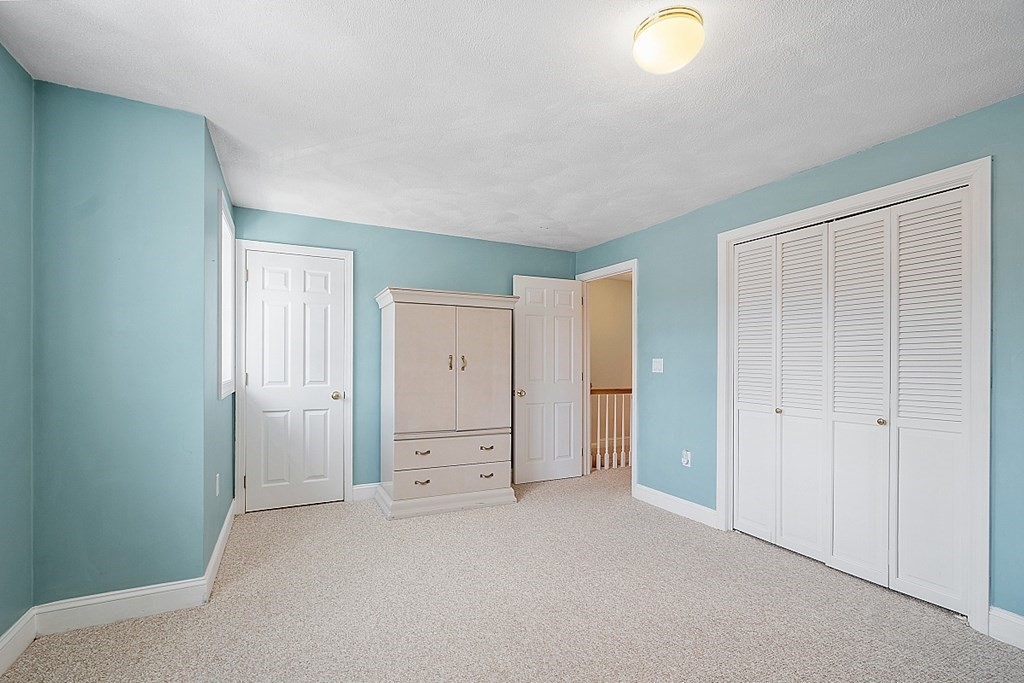 34 Lowell Road, Unit 4 Pepperell, MA 01463 - Photo 14 of 21 an empty room with closet and mirror