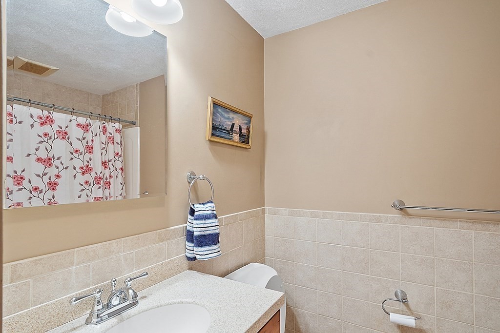 34 Lowell Road, Unit 4 Pepperell, MA 01463 - Photo 17 of 21 a bathroom with a sink a toilet and a mirror