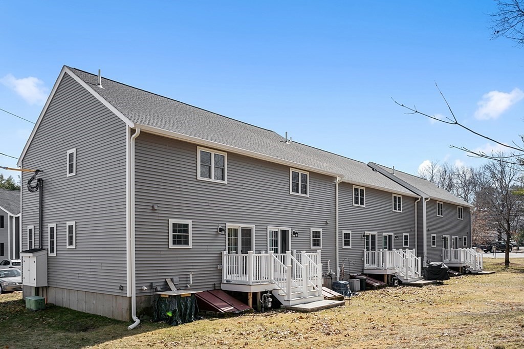 34 Lowell Road, Unit 4 Pepperell, MA 01463 - Photo 2 of 21 a front view of a house with a yard