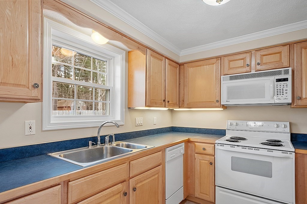 34 Lowell Road, Unit 4 Pepperell, MA 01463 - Photo 4 of 21 a kitchen with a sink cabinets and window