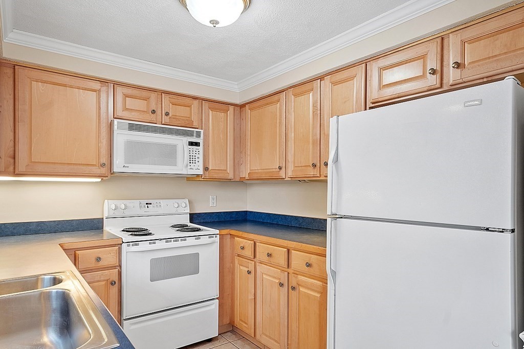 34 Lowell Road, Unit 4 Pepperell, MA 01463 - Photo 5 of 21 a white refrigerator freezer sitting inside of a kitchen