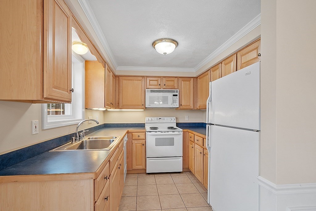 34 Lowell Road, Unit 4 Pepperell, MA 01463 - Photo 6 of 21 a kitchen with a stove a sink and a refrigerator