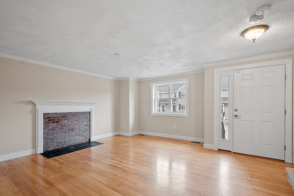 34 Lowell Road, Unit 4 Pepperell, MA 01463 - Photo 9 of 21 a view of an empty room with a window and wooden floor