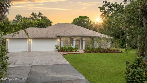 a front view of a house with a yard and trees