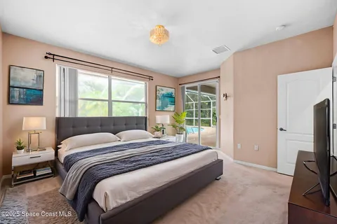 a bedroom with a bed flat screen tv and a large window