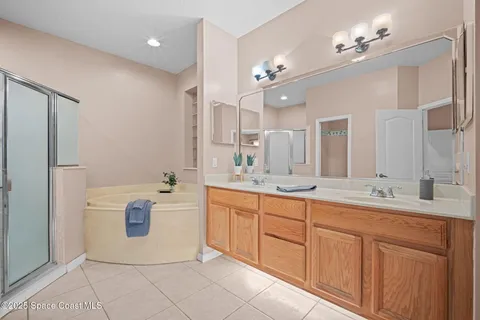 a spacious bathroom with a granite countertop sink a mirror and a bathtub