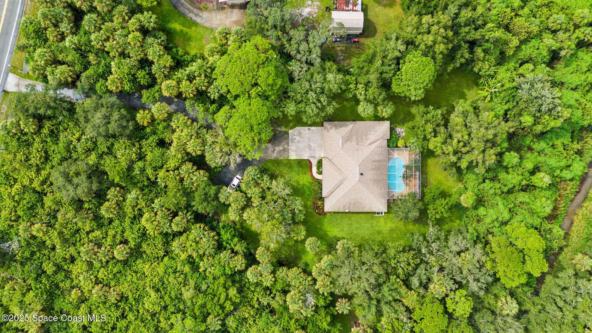 7635 Windover Way Titusville, FL 32780 - Photo 34 of 36 an aerial view of a house with a yard and large trees