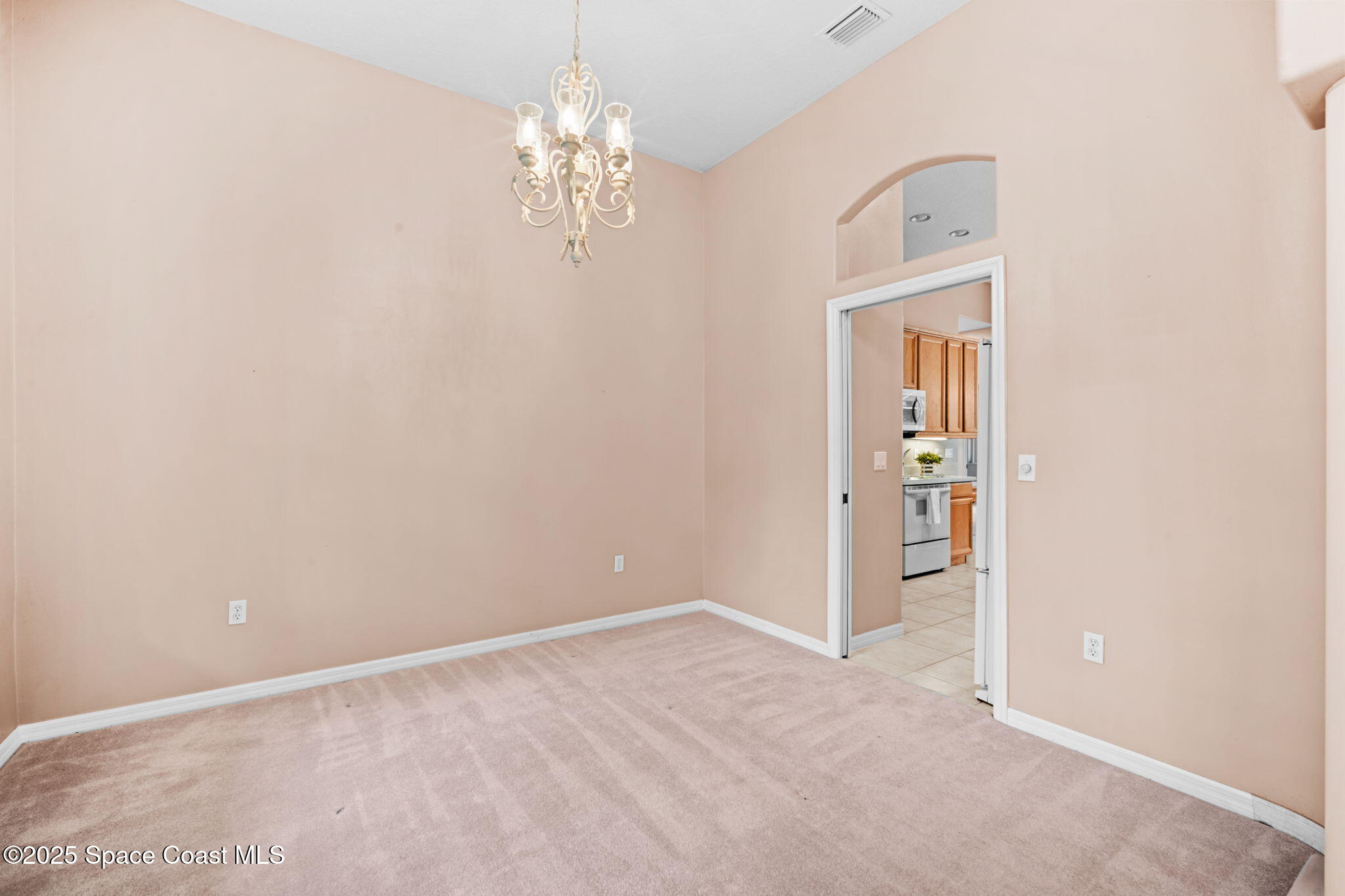 7635 Windover Way Titusville, FL 32780 - Photo 6 of 36 en empty room with windows and chandelier