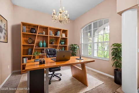 a view of a workspace with furniture and a window