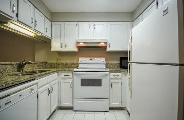 a kitchen with appliances a sink and cabinets