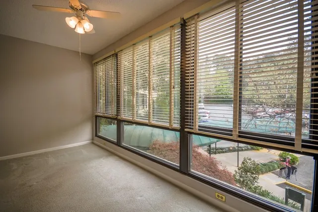 an empty room with a ceiling fan and a window