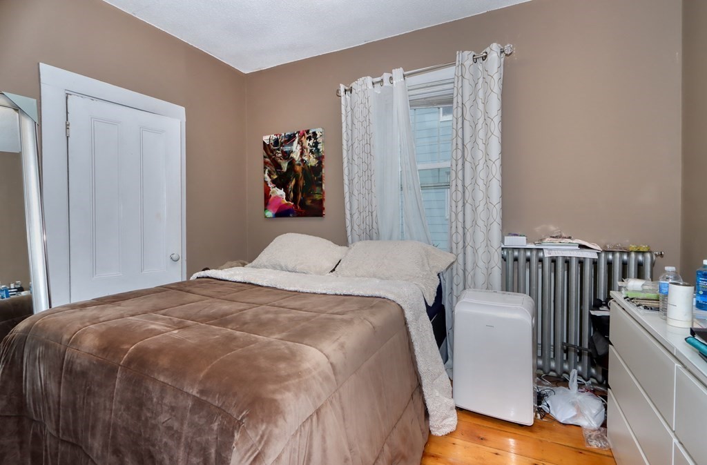 31-33 Rockingham Street Cambridge, MA 02139 - Photo 14 of 22 a bedroom with a bed and a wooden floor