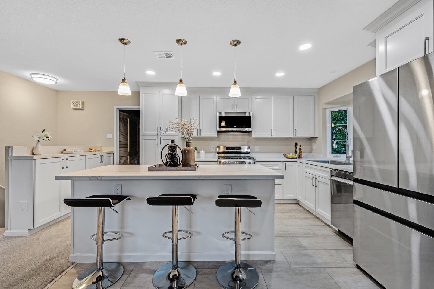 180 Mill Creek Road Fremont, CA 94539 - Photo 10 of 55 a kitchen with stainless steel appliances kitchen island granite countertop a dining table chairs refrigerator and sink
