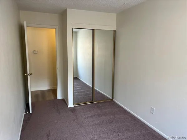 an empty room with windows and closet