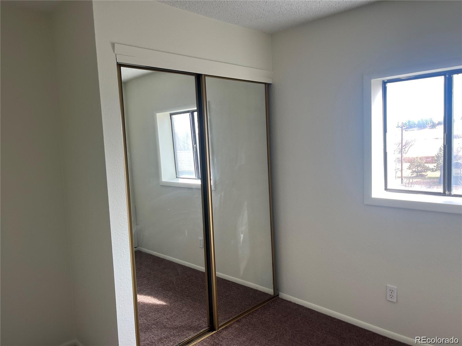 24395 Main Street Elbert, CO 80106 - Photo 12 of 26 an empty room with windows and closet