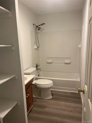 a view of a hallway with wooden floor and a window